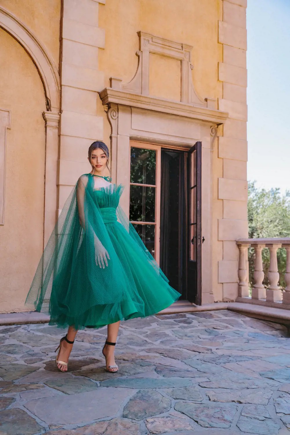 Model wearing a long green evening gown